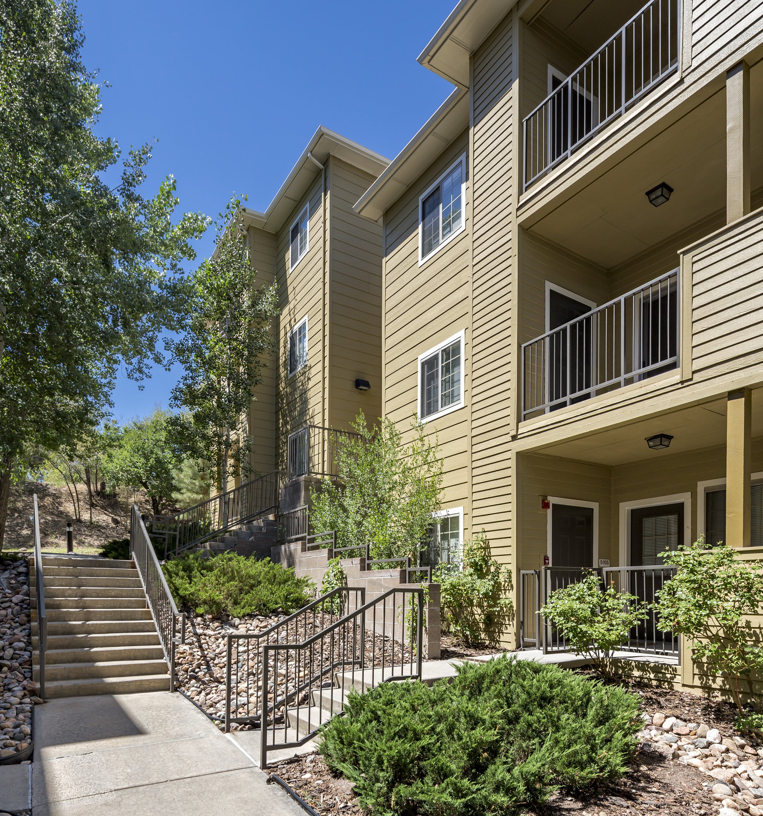 Modern multifamily apartment building with balconies lit by warm golden-hour light