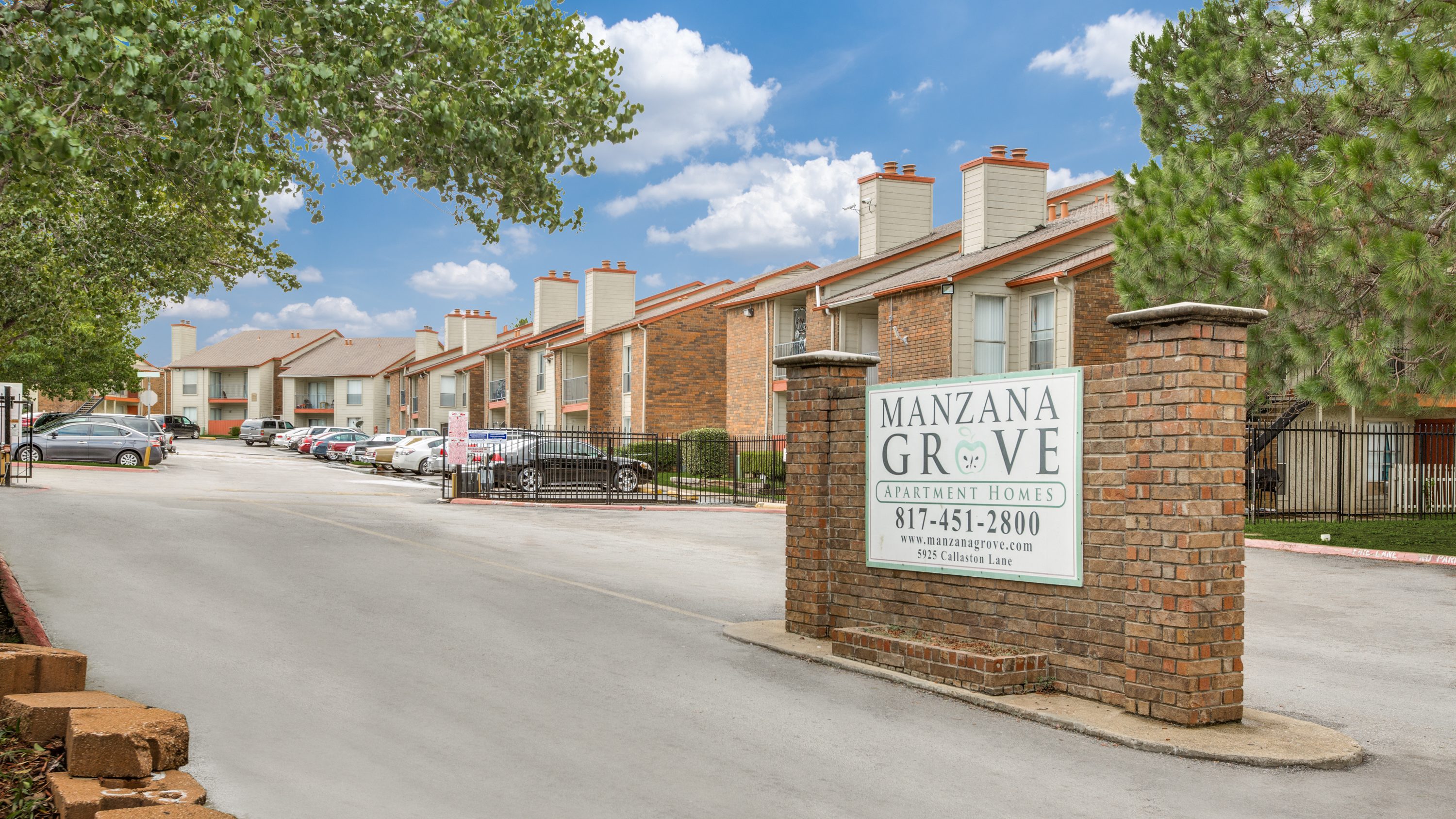 Exterior view of Manzana Grove in Fort Worth, TX featuring signage and buildings.