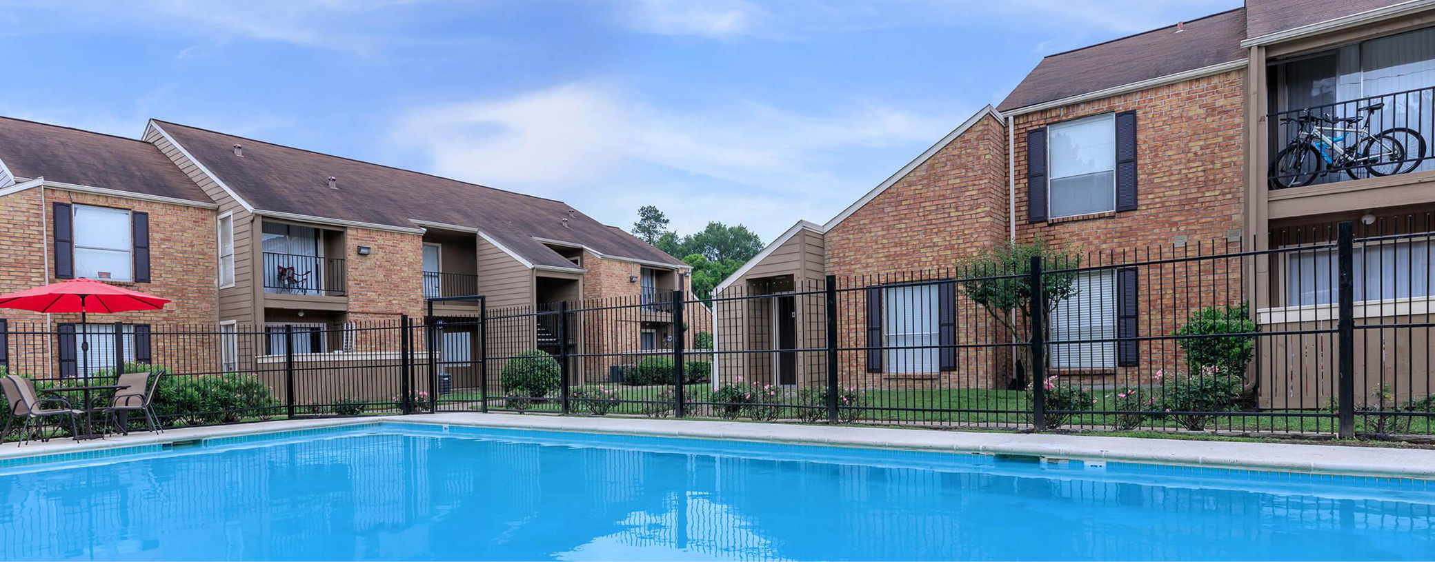 Poolside view of Pebble Creek Apartments with buildings in the background.