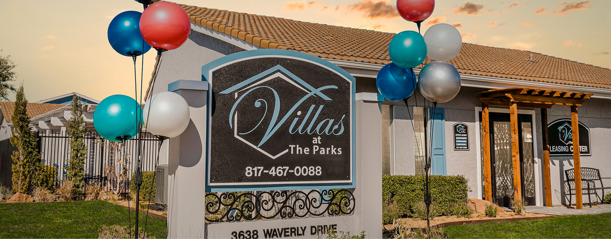 Signage at Villas at the Parks with the leasing center in the background.
